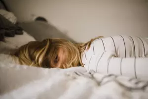 Müde Frau liegt im Bett